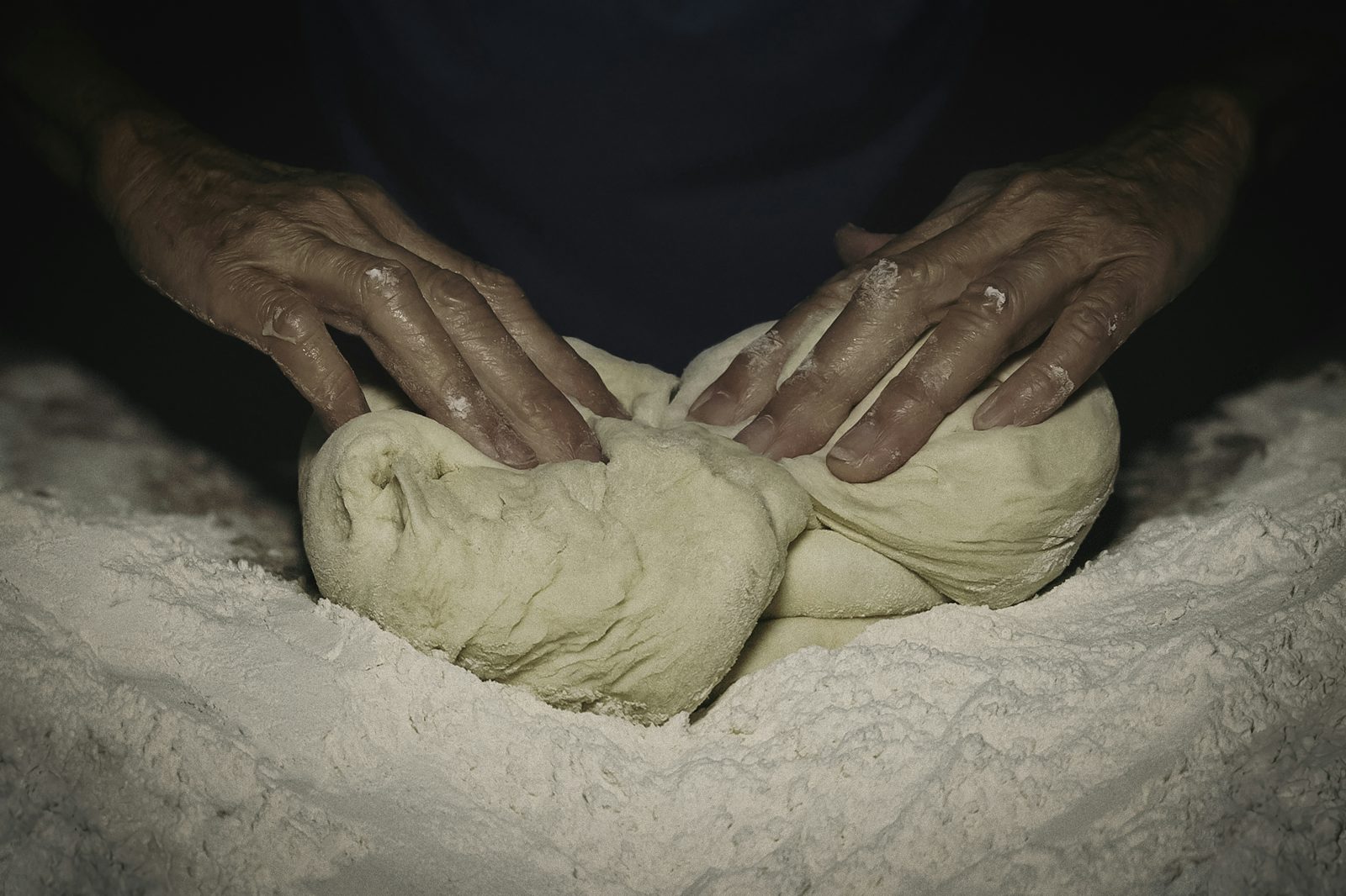Boulanger façonnant le pain au levain dans le fournil de Boulangerie de l'Arnette